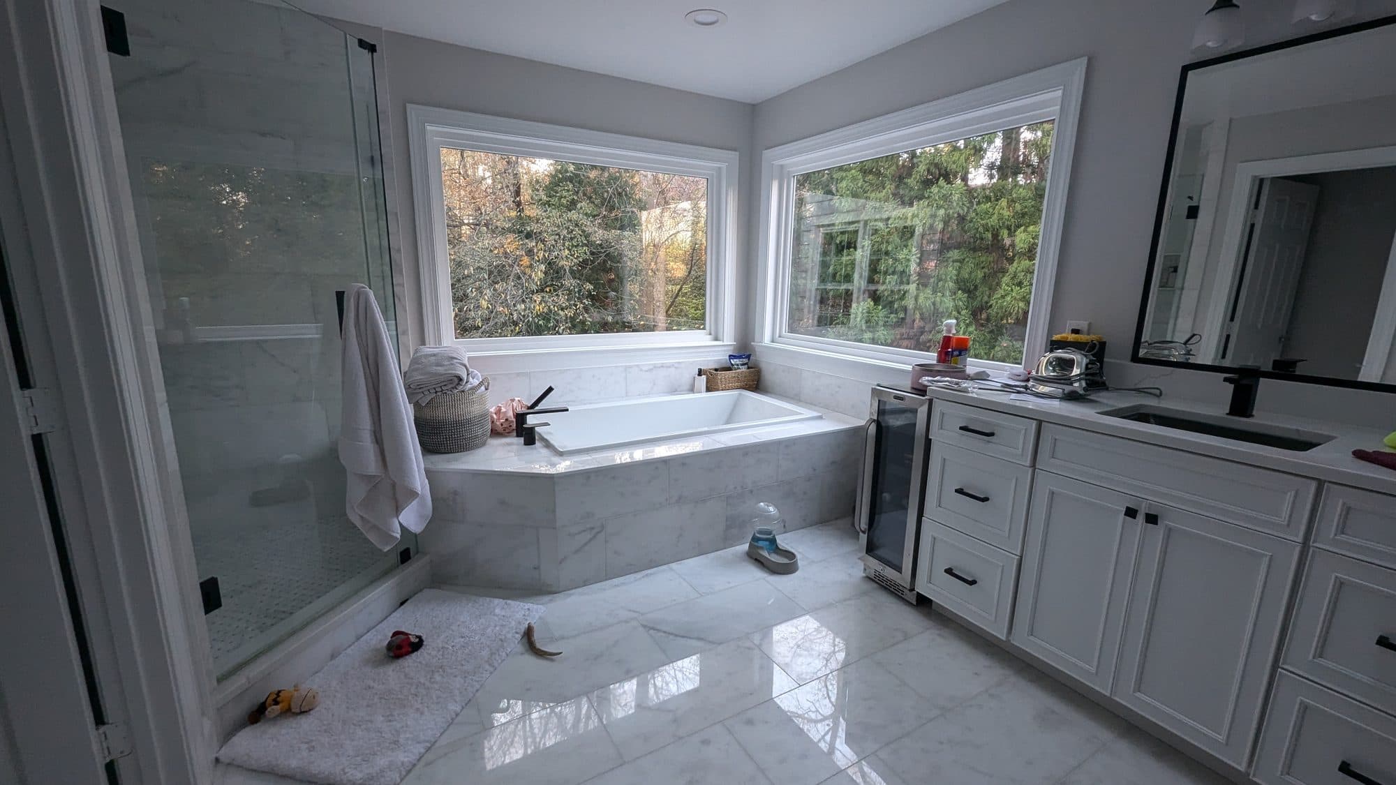 Primary bathroom with a soaking tub, glass shower enclosure, and a large window